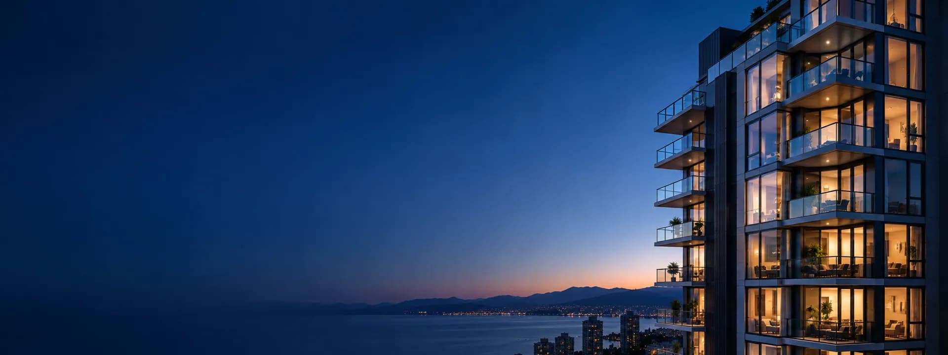 An apartment tower with lit windows at dawn